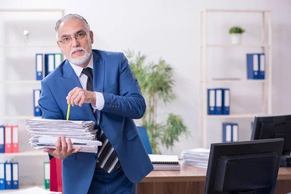 Velho empregado masculino e excesso de trabalho no escritório — Fotografia de Stock