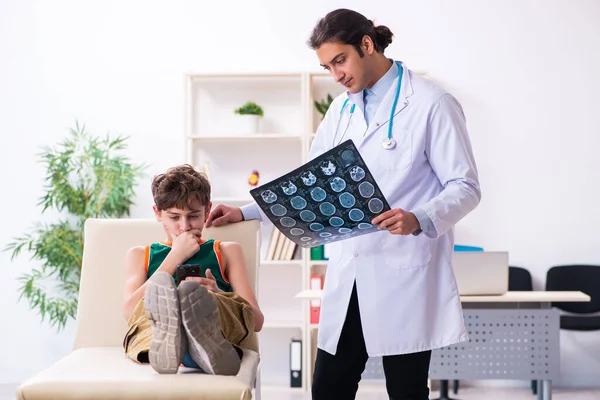 Beteg fiú látogató fiatal férfi orvos gyermekorvos — Stock Fotó
