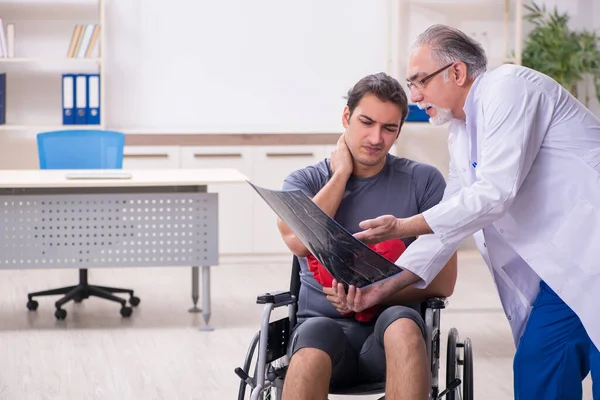 Genç yaralı boksör yaşlı doktor travmatoloğu ziyaret ediyor. — Stok fotoğraf