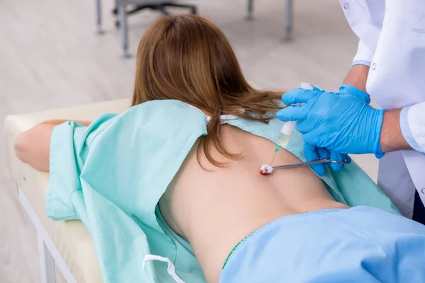 Молодая женщина с травмой спины посещает врача-хиропрактика — стоковое фото