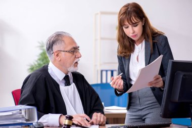 Yaşlı erkek yargıç ve genç sekreteri ofiste.