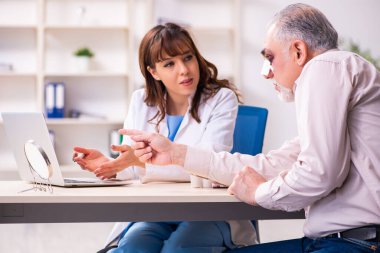 Yaşlı adam estetik ameliyat için genç bayan doktoru ziyaret ediyor.