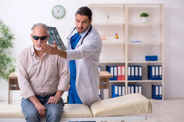 Старий сліпий відвідує молодого лікаря-чоловіка — стокове фото