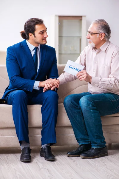 Jonge mannelijke advocaat op bezoek oude man in testament concept — Stockfoto