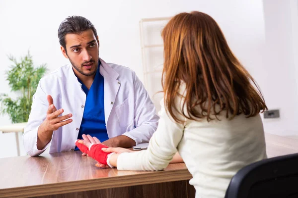 Jeune femme blessée à la main visitant un médecin traumatologue — Photo