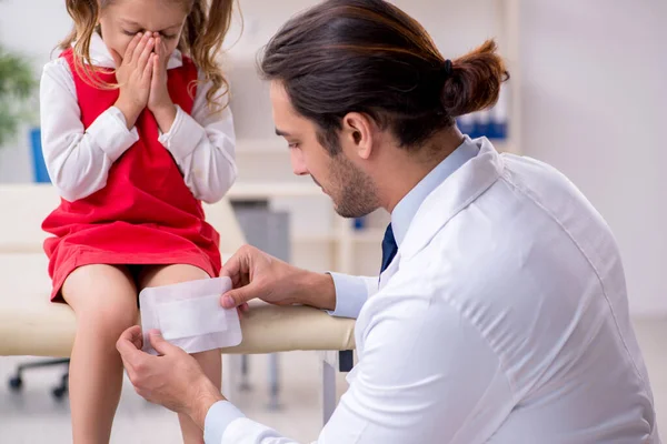 Kleines Mädchen besucht junge männliche Ärztin — Stockfoto