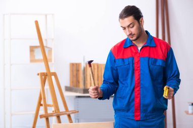 Genç erkek müteahhit atölyede çalışıyor.