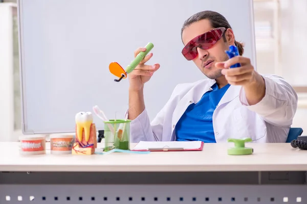 Young male dentist working in the clinic