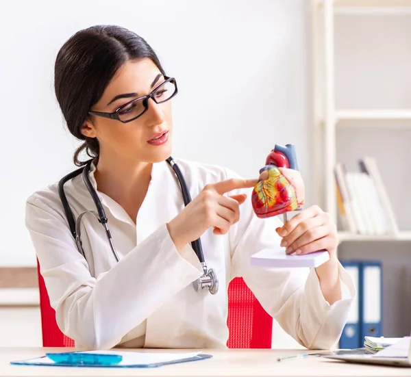 Donna medico mostrando modello di cuore agli studenti — Foto Stock