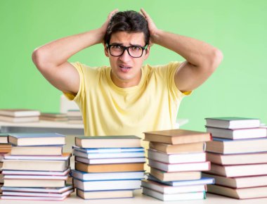 Sınavdan önce okumak için çok fazla kitabı olan öğrenci