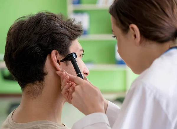 Жінка-лікар перевіряє вухо пацієнтів під час медичного огляду — стокове фото