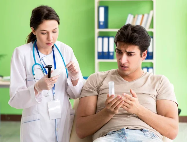 Médica verificando pacientes ouvido durante o exame médico — Fotografia de Stock