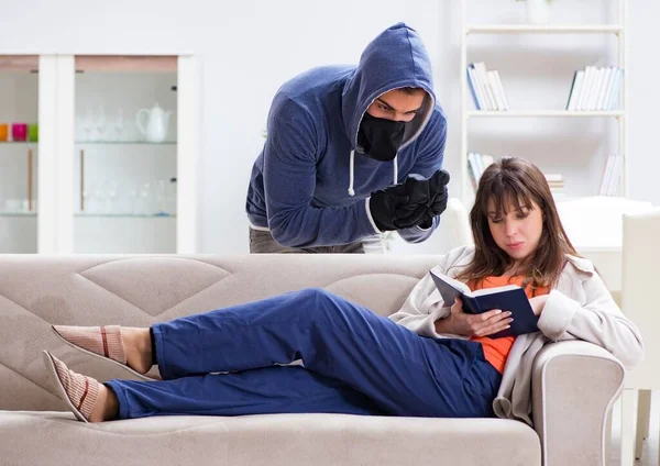 Bewaffneter Mann überfällt junge Frau zu Hause — Stockfoto