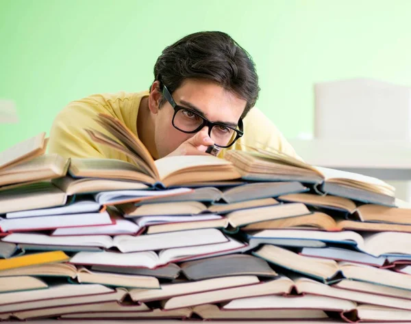 Sınavdan önce okumak için çok fazla kitabı olan öğrenci