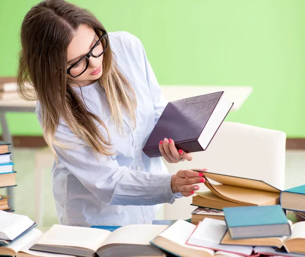 Jovem estudante se preparando para exames com muitos livros — Fotografia de Stock