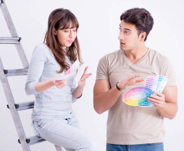 Genç bir aile evlerinde tadilat yapıyor. Duvarları boyuyor.