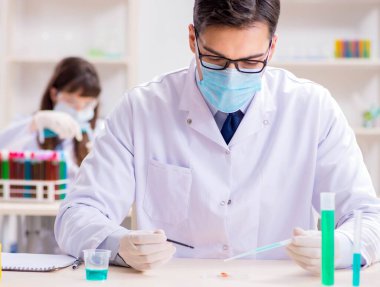 Laboratuvarda deney yapan iki kimyager.