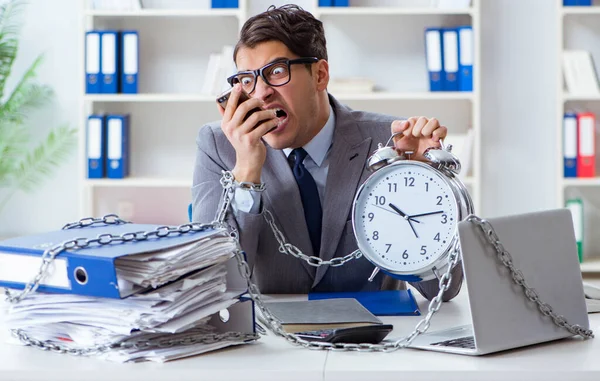 Busy employee chained to his office desk — Stock Photo, Image