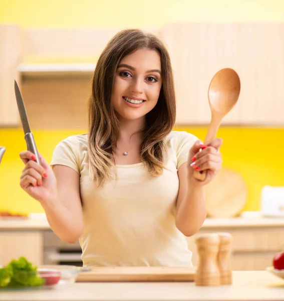 Νεαρή γυναίκα ετοιμάζει σαλάτα στο σπίτι στην κουζίνα — Φωτογραφία Αρχείου
