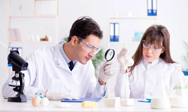 Dois médicos de laboratório testando produtos alimentares — Fotografia de Stock