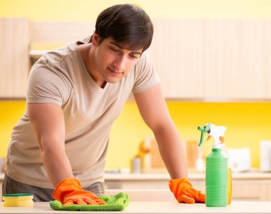 Bekar adam mutfağı temizliyor.