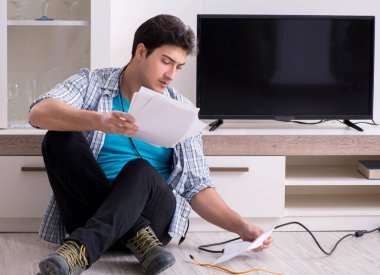 Bozuk televizyonu tamir etmeye çalışan adam