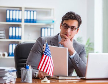 Ofisinde Amerikan bayrağı taşıyan bir iş adamı