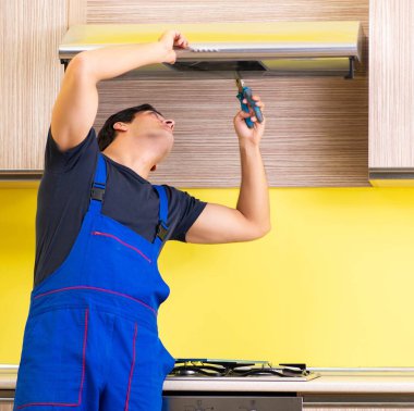 Genç müteahhit mutfak mobilyalarını monte ediyor.