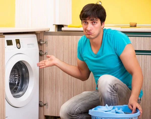 Joven marido hombre haciendo la colada en casa — Foto de Stock