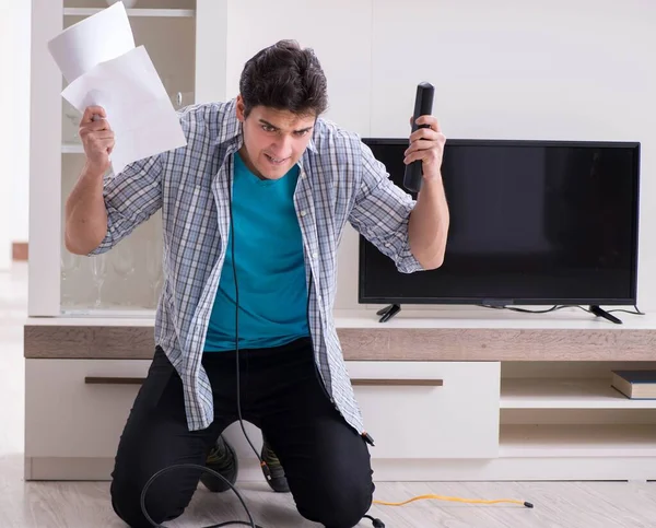 Bozuk televizyonu tamir etmeye çalışan adam