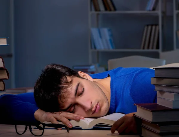 Estudiante preparándose para los exámenes tarde en la noche en la biblioteca — Foto de Stock