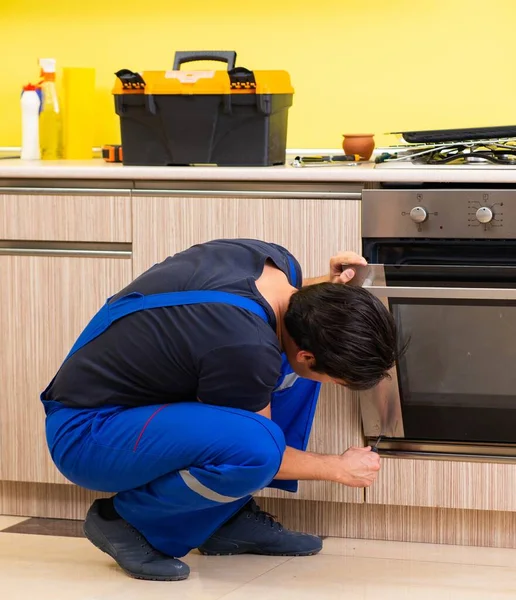 Junger Dienstleister montiert Küchenmöbel — Stockfoto