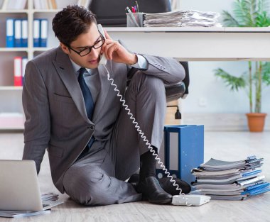 İş adamı ofiste çalışıyor ve oturuyor.