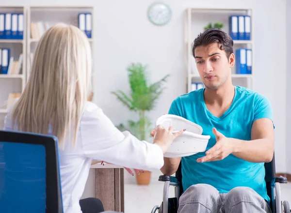 Disabled man in wheel chair visiting woman doctor — Stock Photo, Image