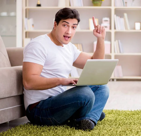 Man werkt op laptop thuis op tapijt vloer — Stockfoto