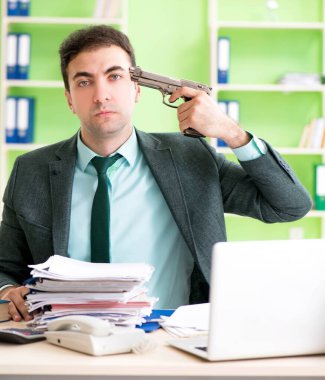 İşadamı ofiste otururken aşırı çalışmaktan kızgın.