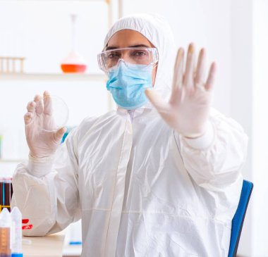 Laboratuvarda kimyasallar üzerinde çalışan genç bir kimyager.