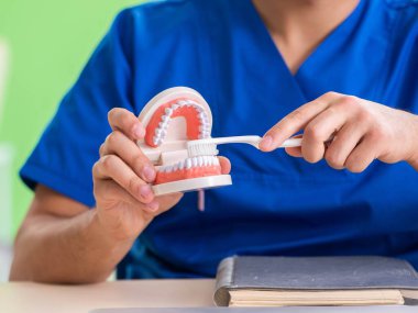 Erkek dişçi yeni diş implantı üzerinde çalışıyor.
