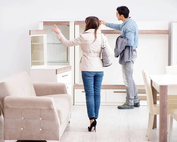 Mağazadaki evli çift mobilya seçiyor.