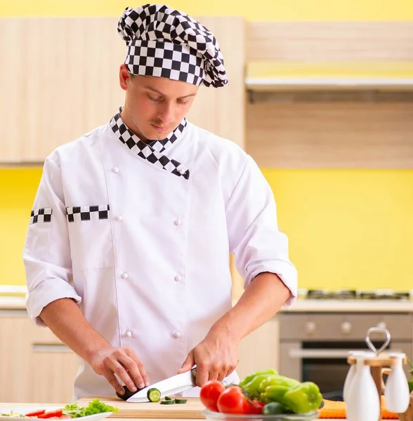 Joven cocinero profesional preparando ensalada en la cocina — Foto de Stock