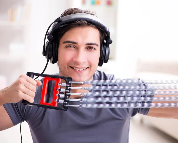Man die sport beoefent met verzetsband en naar muziek luistert — Stockfoto