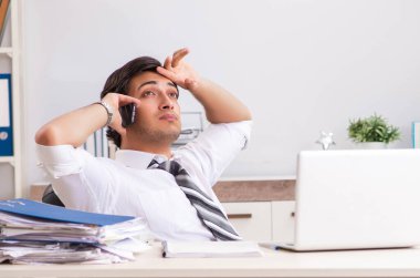 Genç yakışıklı işadamı ofiste çalışıyor.