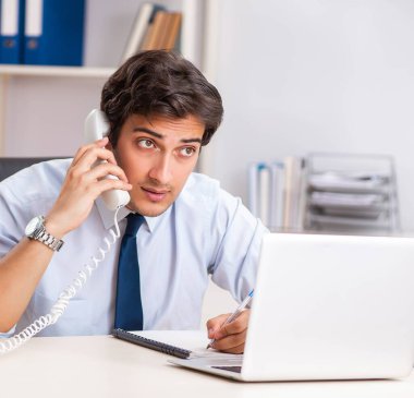 Genç çağrı merkezi operatörü telefonda konuşuyor.