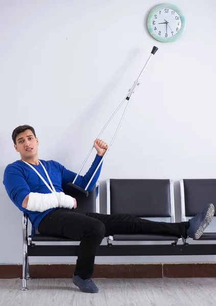 Verzweifelter Mann wartet mit gebrochenem Bein auf seinen Termin im Krankenhaus — Stockfoto