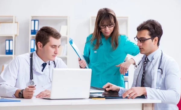 Tres médicos discutiendo los resultados de la exploración de la imagen de rayos X — Foto de Stock