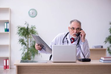 Klinikte çalışan yaşlı bir erkek radyolog.