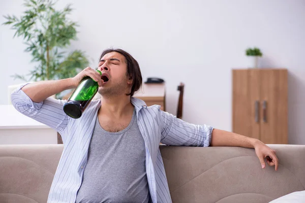 Jovem alcoólico do sexo masculino bebendo vinho em casa — Fotografia de Stock