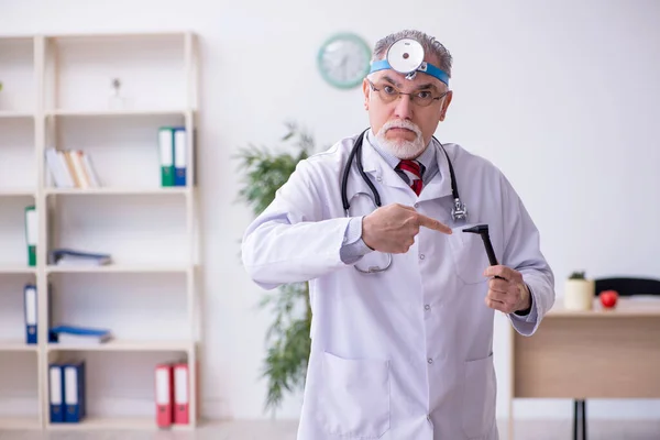 Oude mannelijke arts otoloog werkzaam in de kliniek — Stockfoto