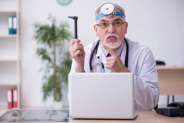 Old male doctor otologist working in the clinic — Stock Photo, Image
