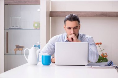 Evde çalışan genç bir erkek.